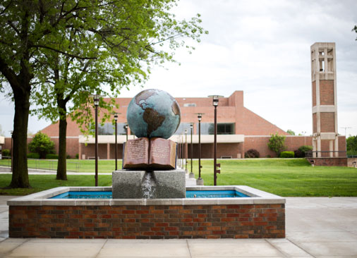Bolivar campus forum with globe water sculpture in foreground and chapel in background