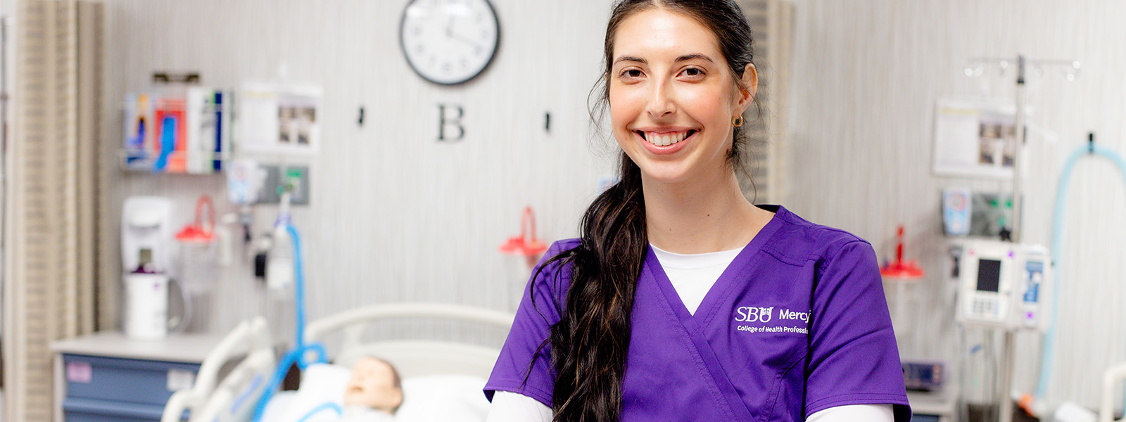 nursing student poses in scrubs